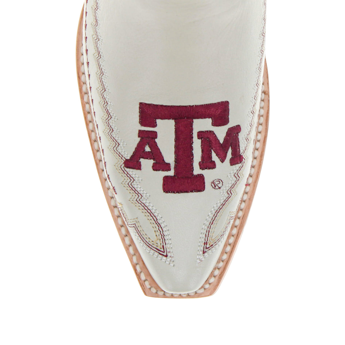 Close-up of cream boot toe with maroon A&M logo and decorative stitching
