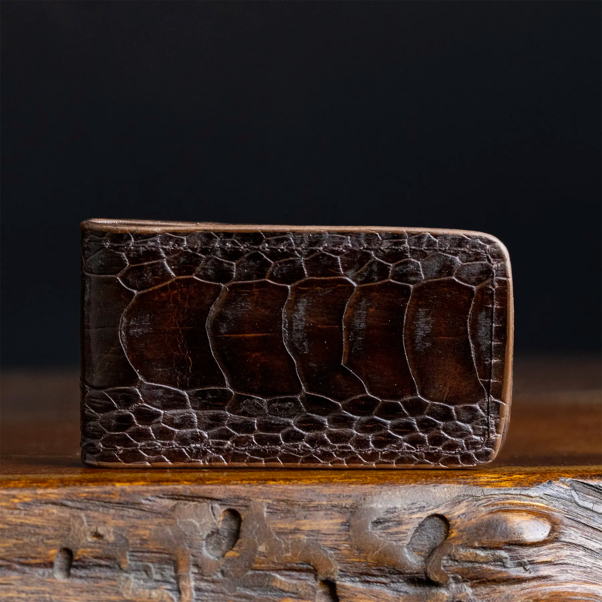 Ostrich leg leather money clip, dark brown textured finish with curved edges