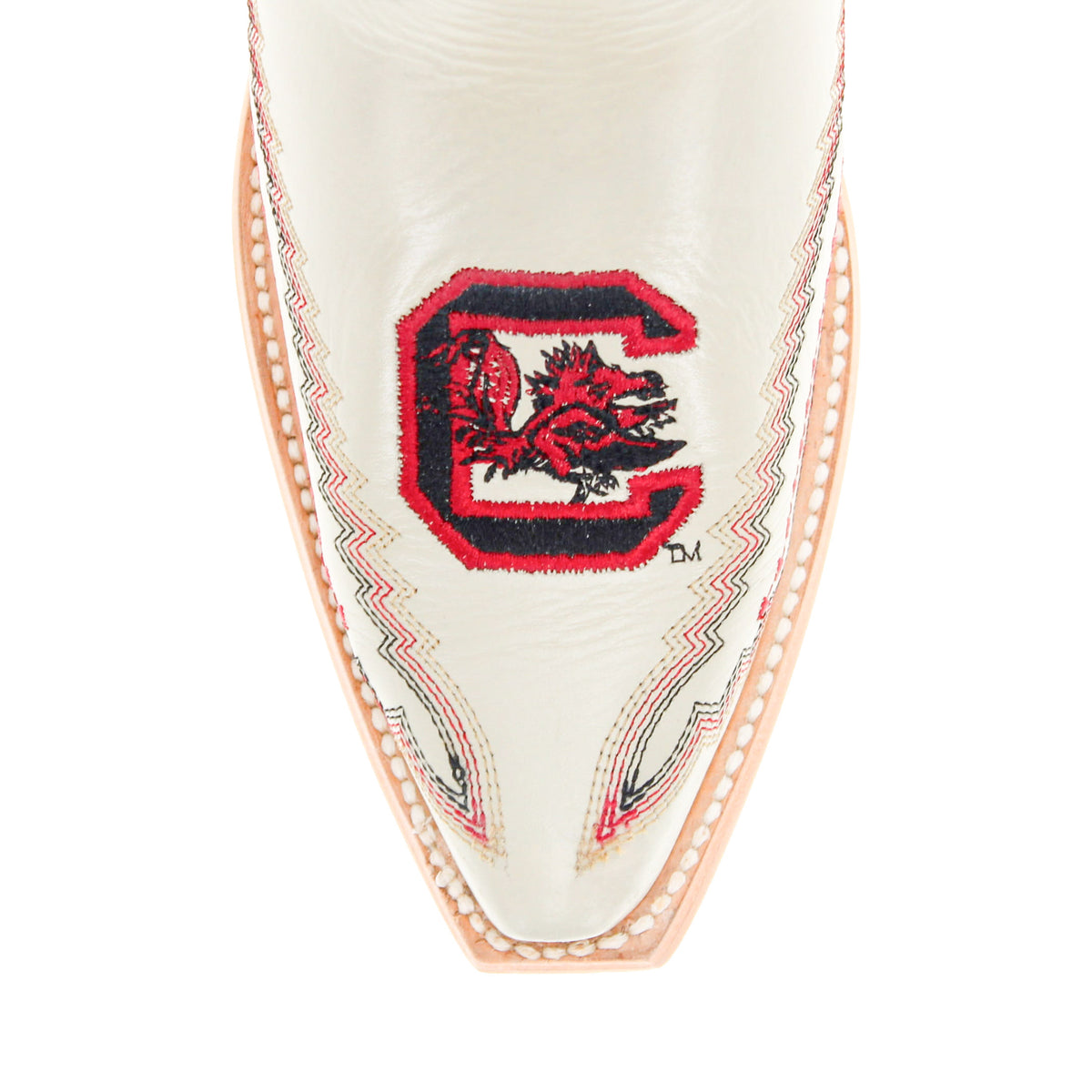 Close-up of cream cowboy boot with red circular emblem and zigzag stitching