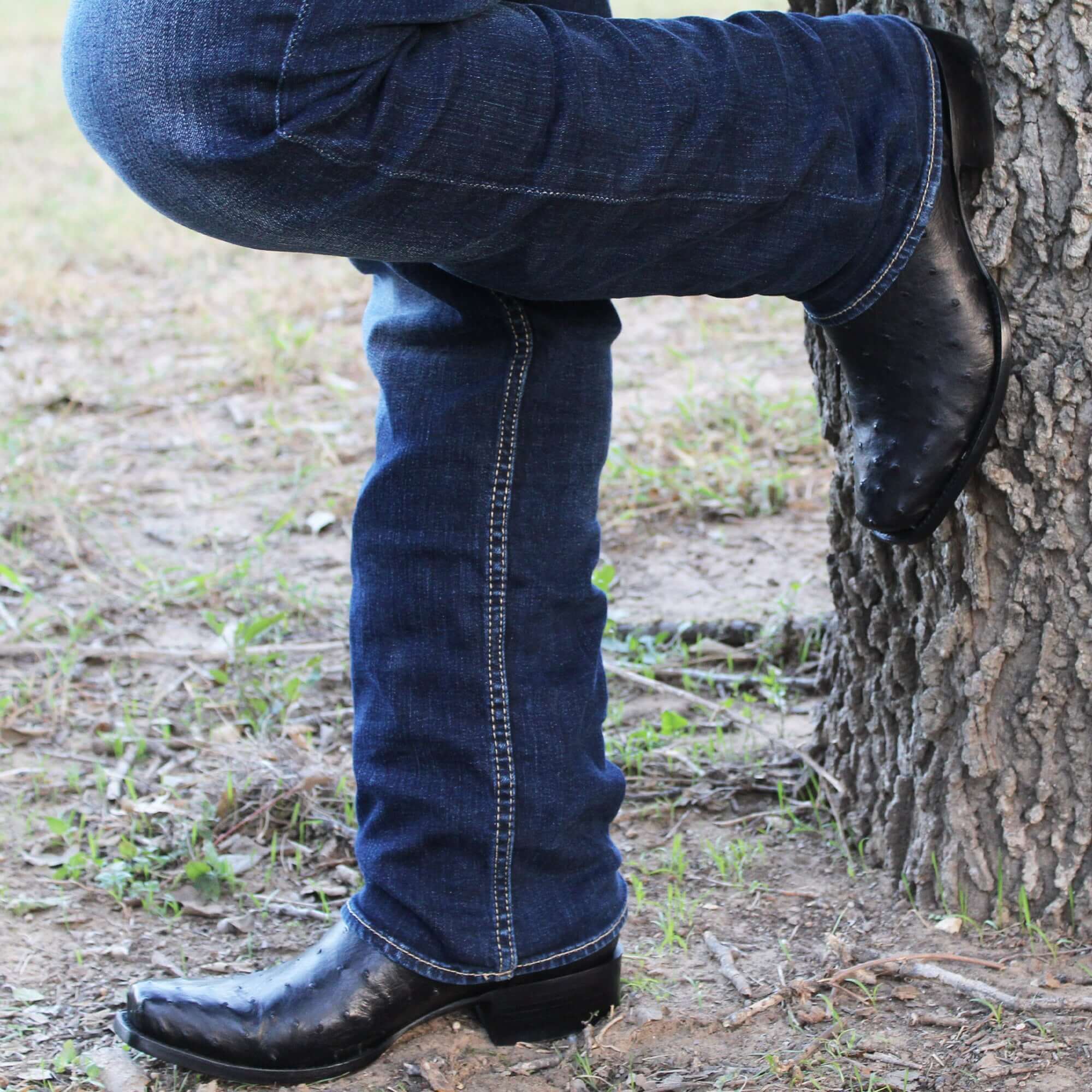 Mens black leather western boots with round toe and decorative stitching, featuring full-quill ostrich leather on the foot for added texture.
