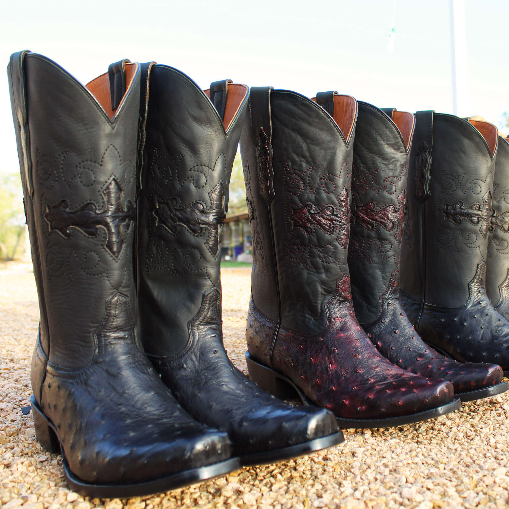 Mens black leather western boots with round toe and decorative stitching, featuring full-quill ostrich leather on the foot for added texture.