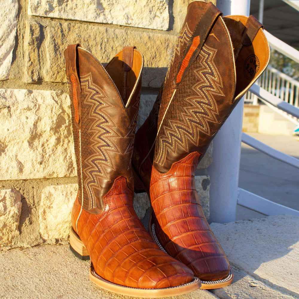 Mens black leather western boots with round toe and decorative stitching, featuring full-quill ostrich leather on the foot for added texture.
