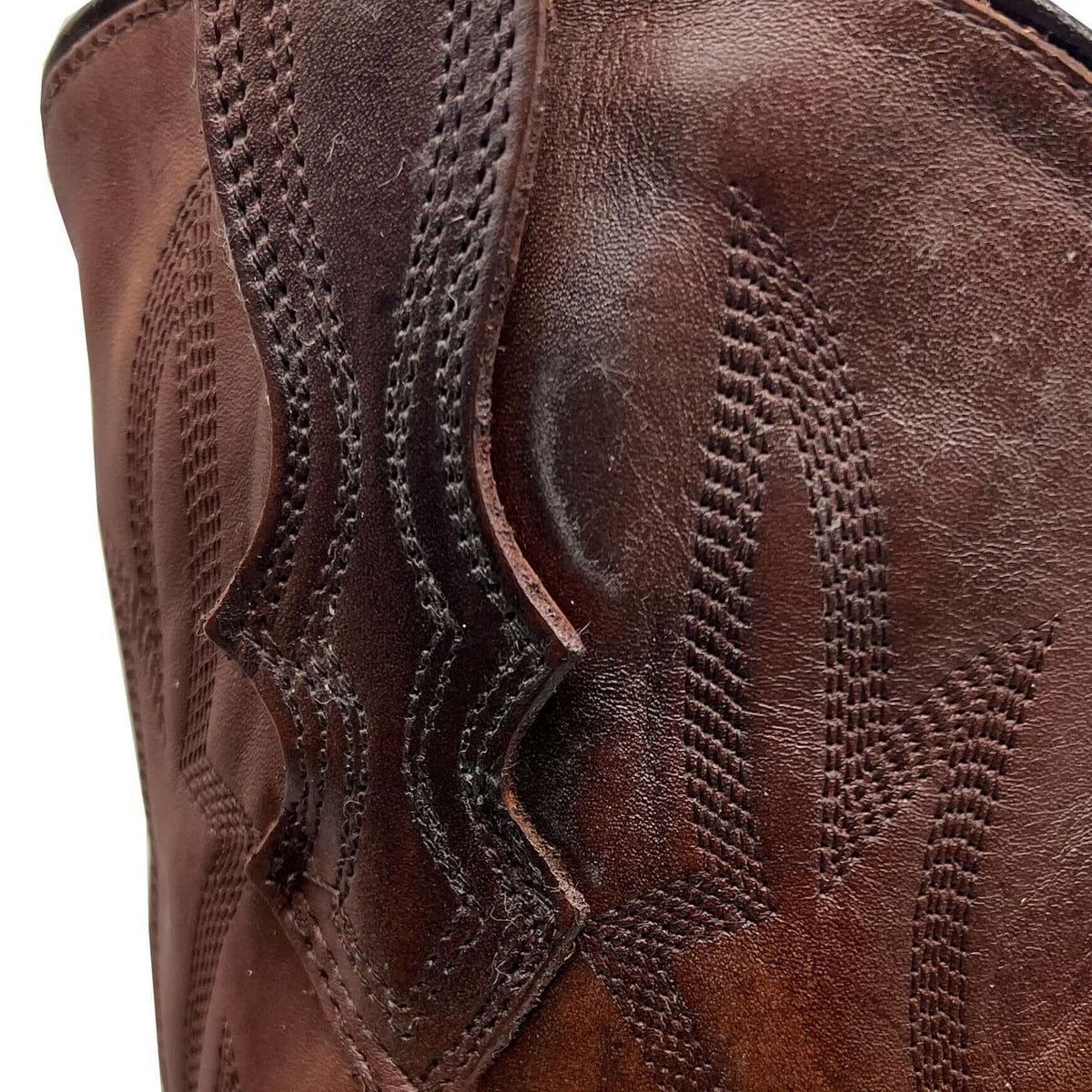 Brown leather boot shaft with decorative channel stitching and textured leather