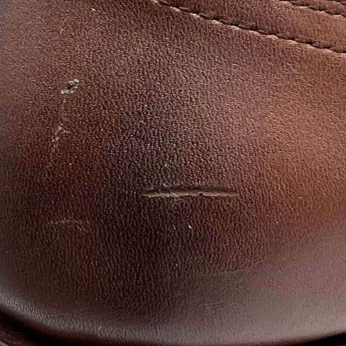 Brown leather boot side with seam stitching and minor scuffs