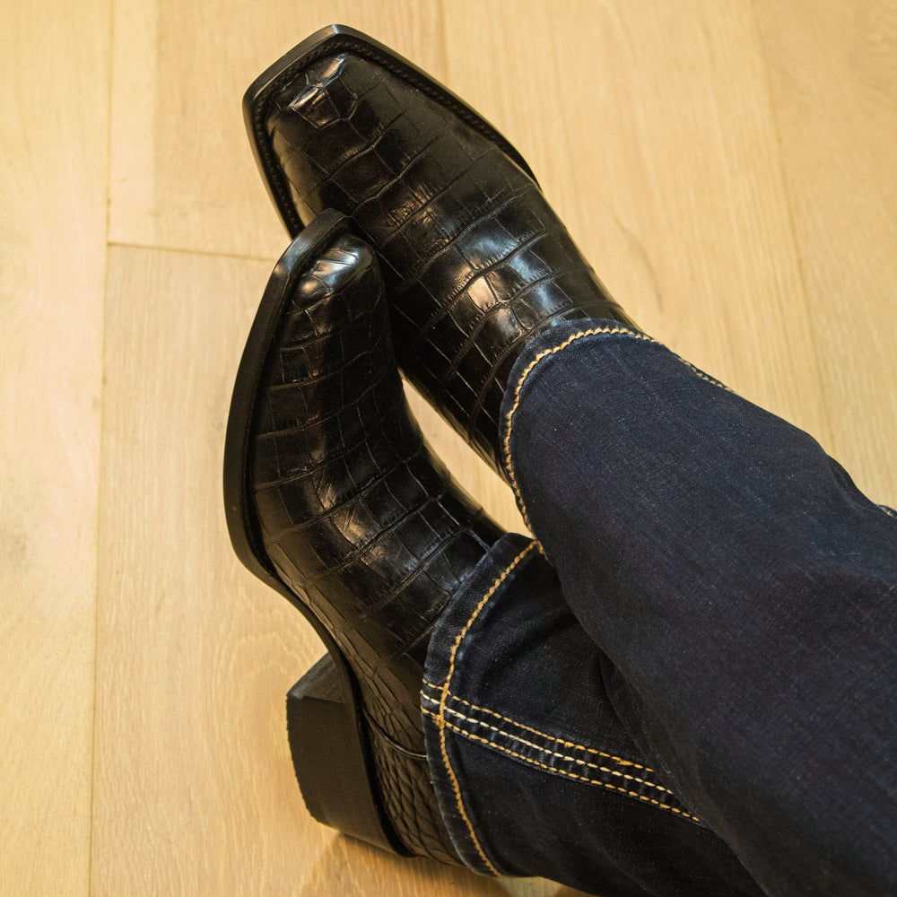 Pair of black alligator cowboy boots with caiman crocodile texture