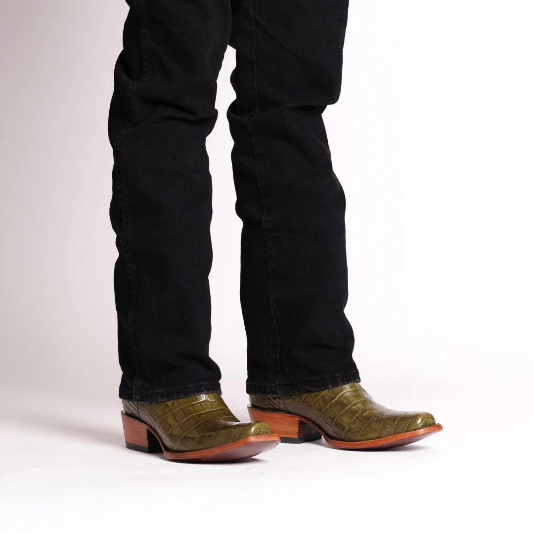 Dark olive western cowboy boots with brown heel, paired with black jeans