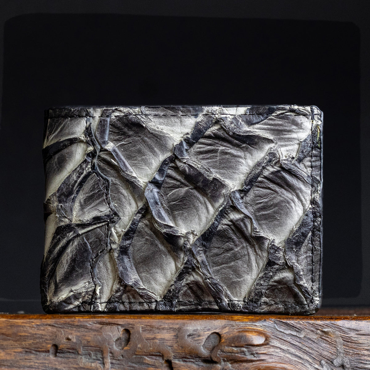 Textured fish-scale leather wallet front panel in dark gray-black