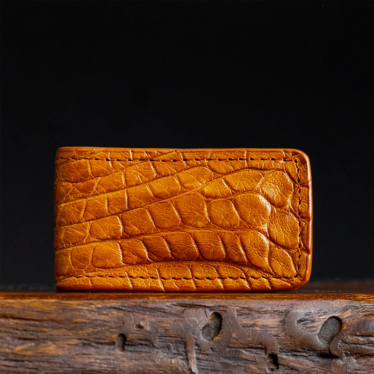 Crocodile-texture leather money clip, tan-orange finish with curved edges