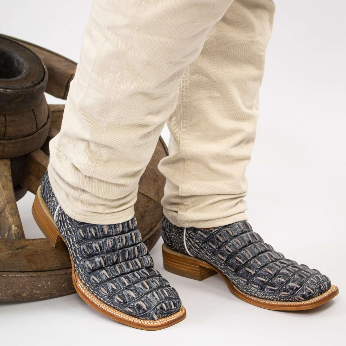 Pair of black crocodile-style cowboy boots with tan sole edges