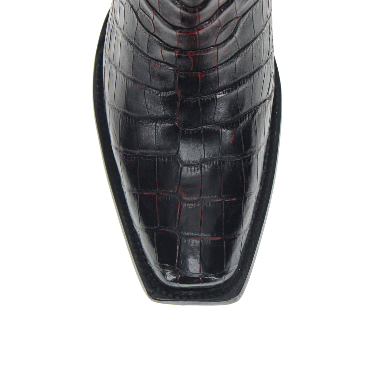Black cowboy boot close-up of front toe with croc-embossed texture
