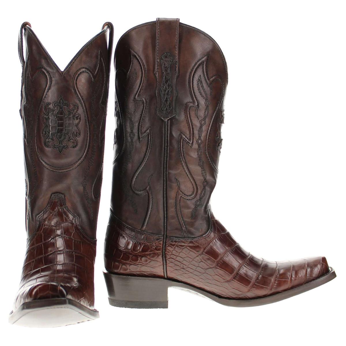 Pair of dark brown cowboy boots with pointed toes and embossed decorative panels