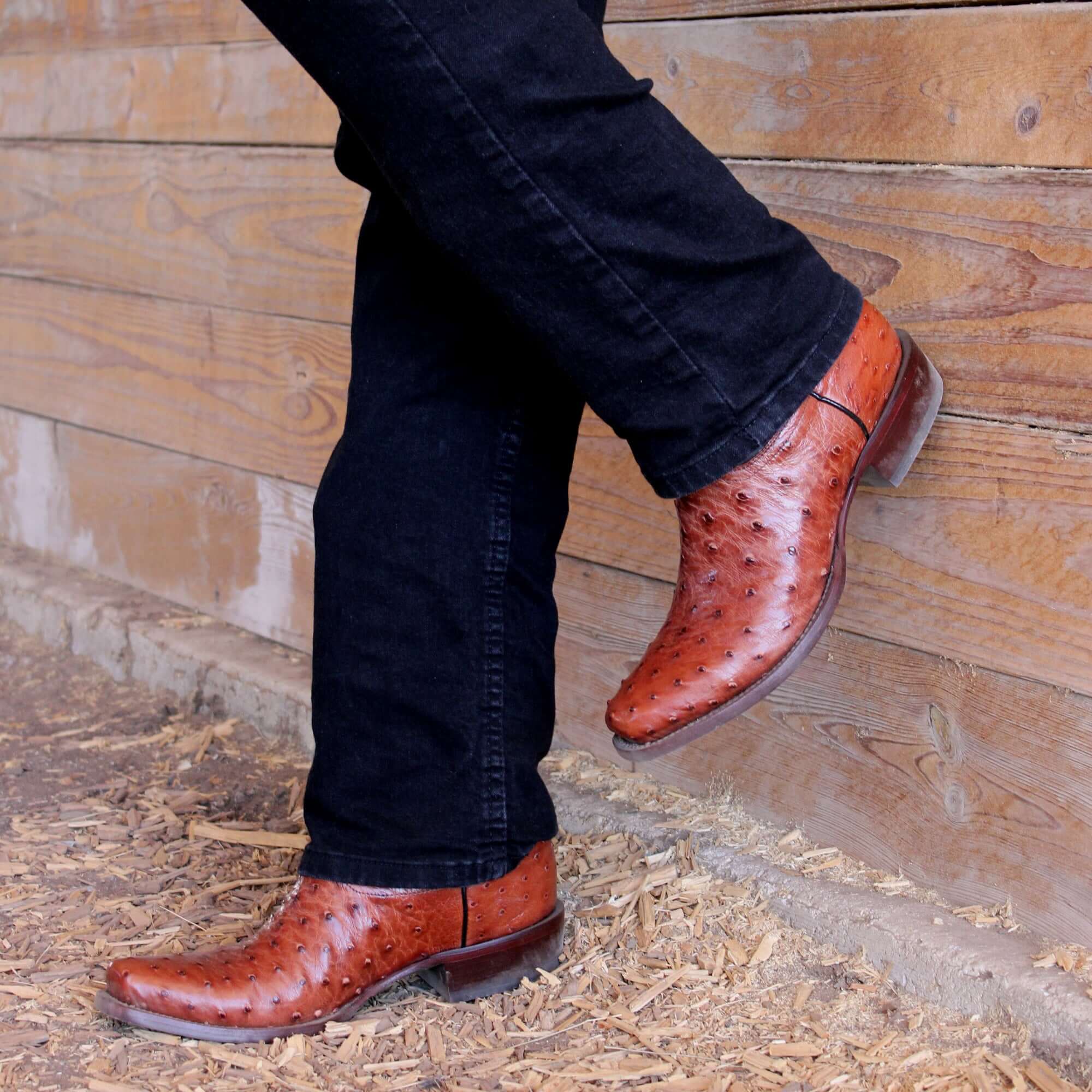 Mens congac leather western boots with narrow square toe and decorative stitching, featuring full-quill ostrich leather on the foot for added texture.