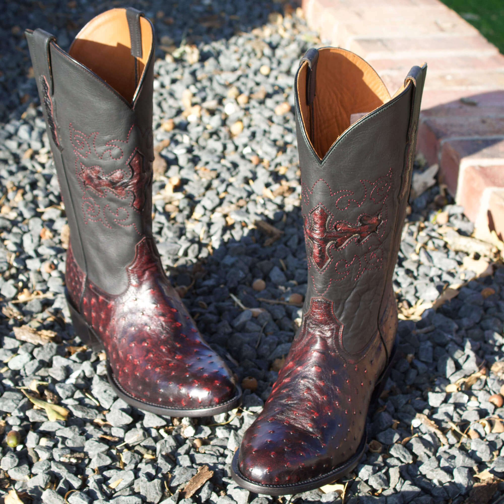 Mens black leather western boots with round toe and decorative stitching, featuring full-quill ostrich leather on the foot for added texture.