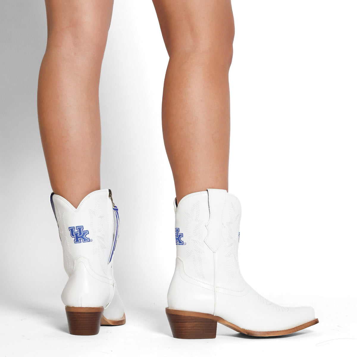 White cowboy boots with blue logo, mid-calf shaft and wooden block heel, back view