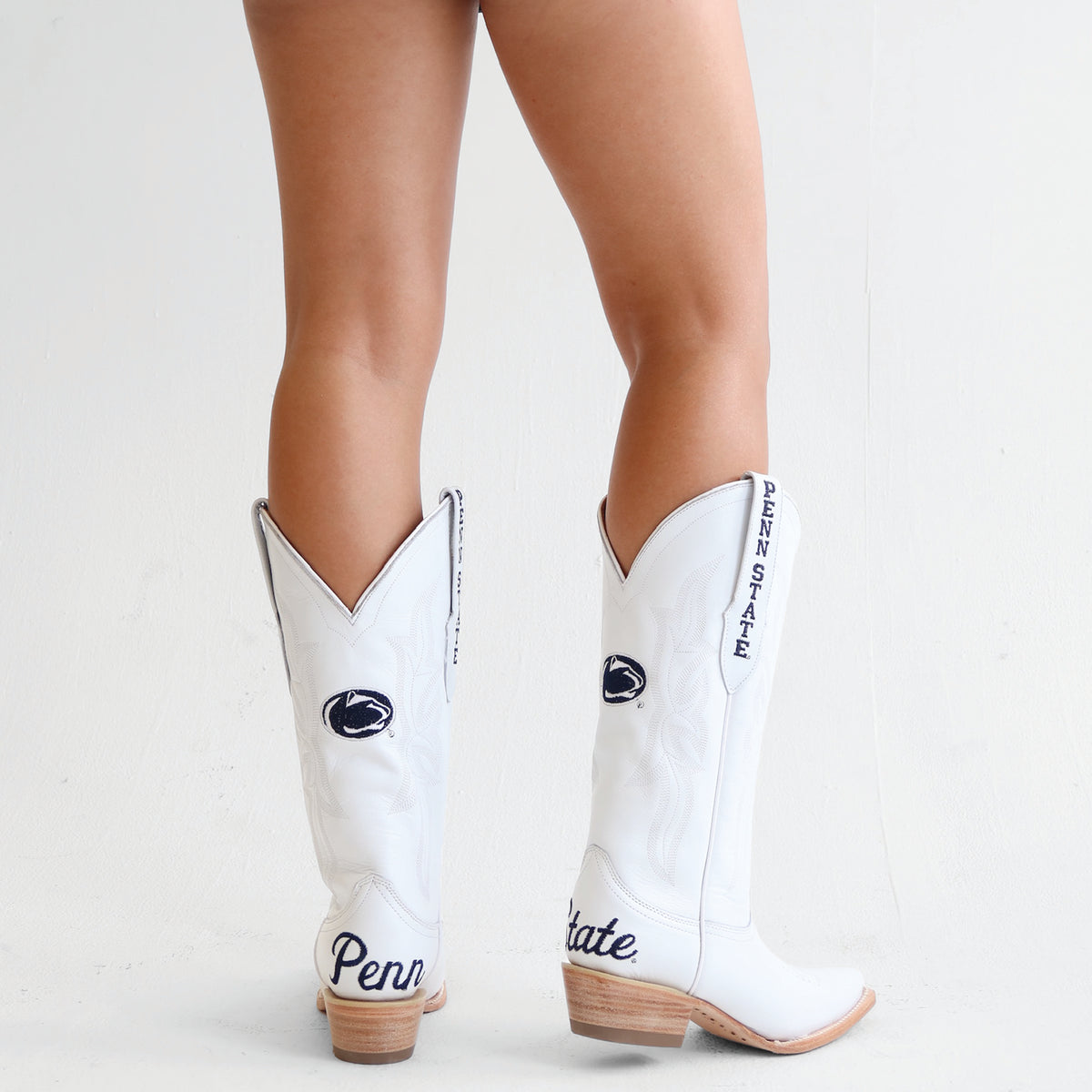 White cowboy boots with Penn State logo, angled view, brown heel and sole