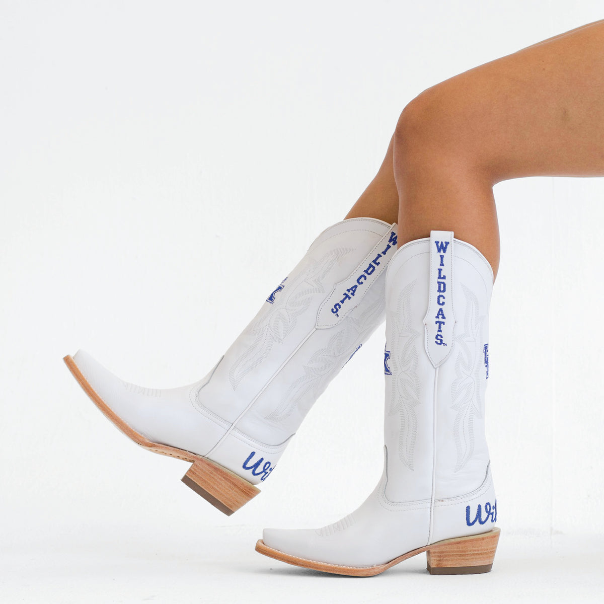 White cowboy boots with blue Wildcats lettering, tan heel and stitched panels
