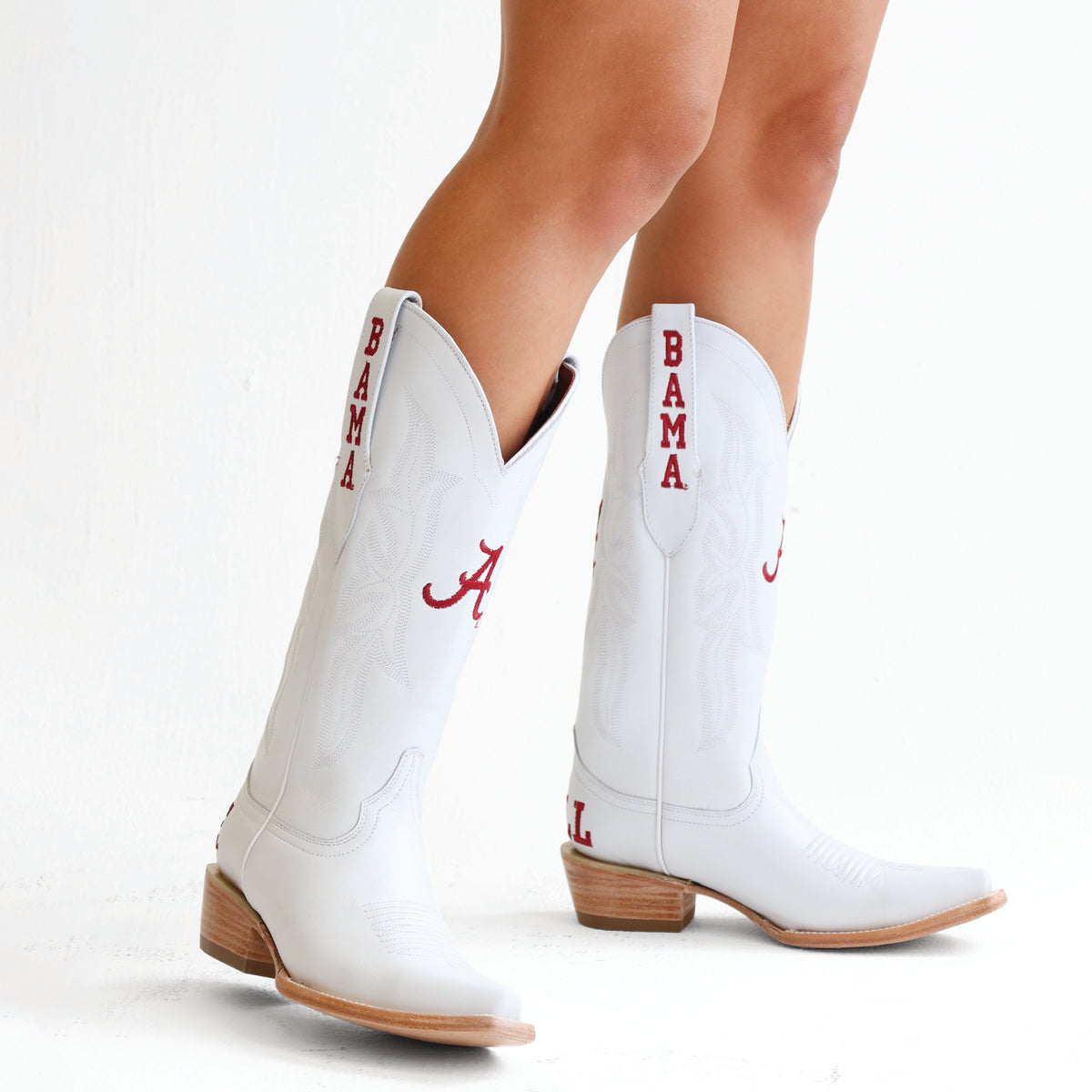 White cowboy boots with side embroidery and red vertical text, tan stacked heel