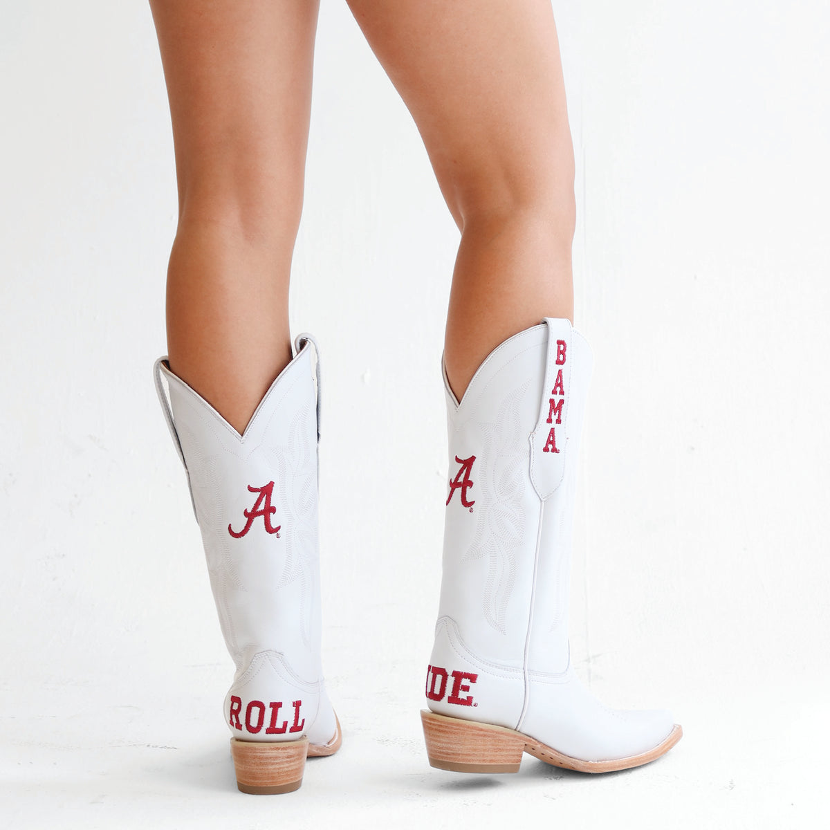 White cowboy boots with red and blue embroidery, tan heels and stitched panels