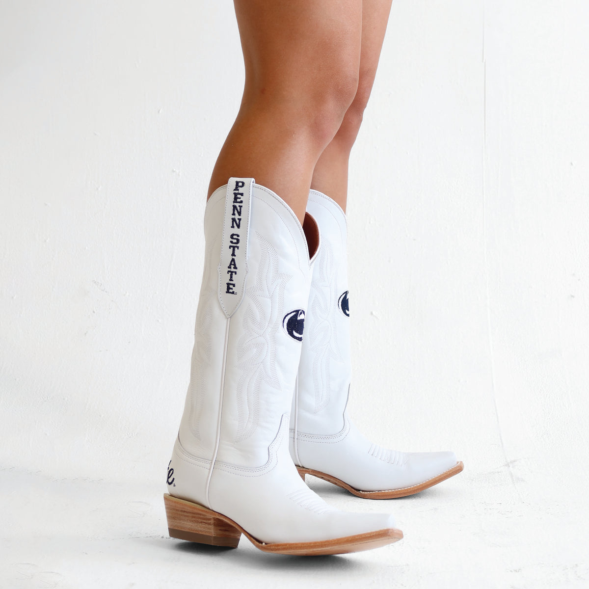 White cowboy boots with Penn State embroidery, side view, brown heel and sole