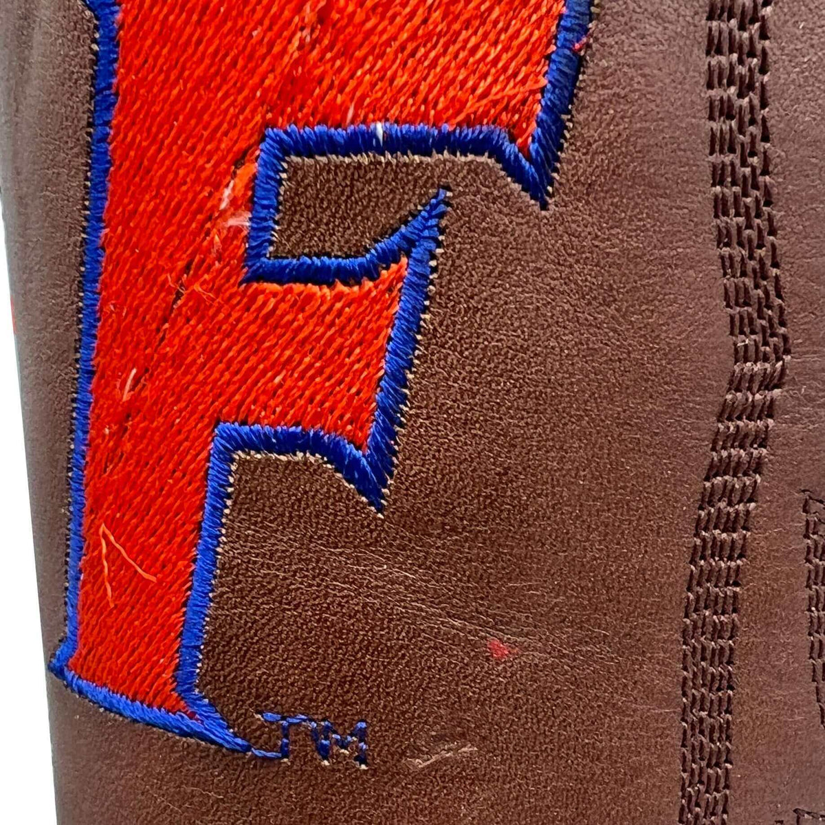 Brown leather cowboy boot side embroidery with blue outline and red letter patch