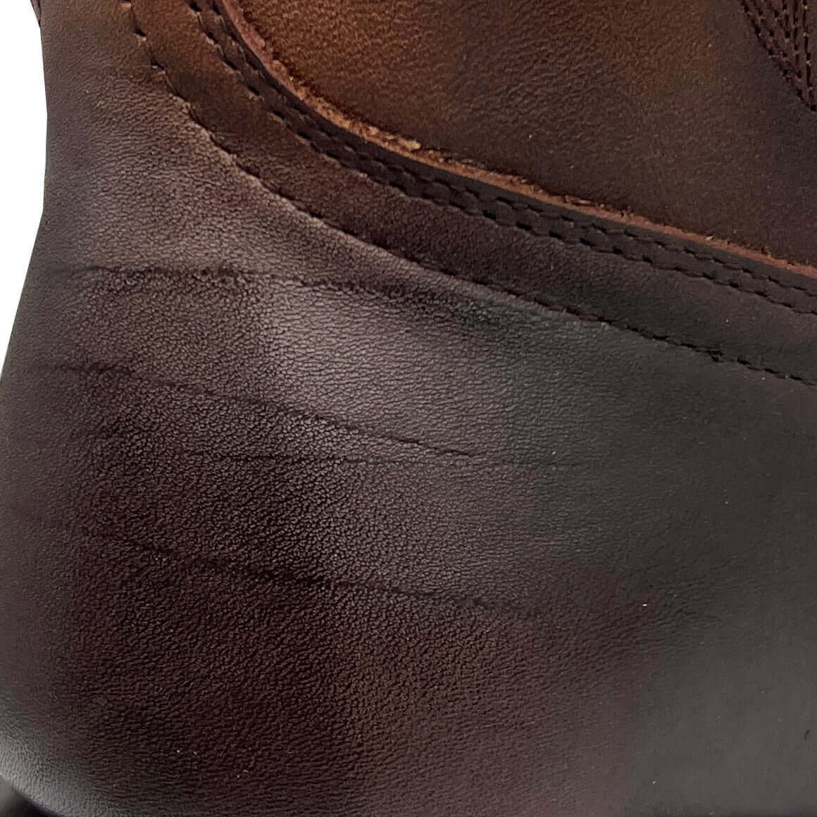 Brown leather boot upper with stitched trim along the collar edge